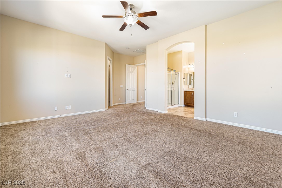 60 Newton Ridge Way Las Vegas, NV 89183 - Photo 29 of 44 Unfurnished room with light colored carpet, arched walkways, and ceiling fan