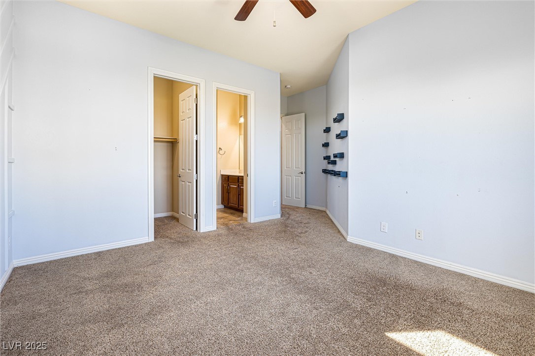 60 Newton Ridge Way Las Vegas, NV 89183 - Photo 31 of 44 Unfurnished bedroom with a spacious closet, light carpet, ceiling fan, and ensuite bath