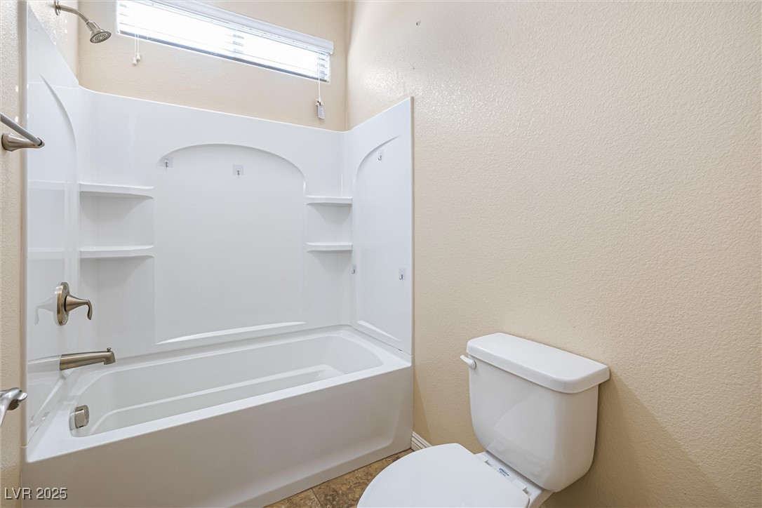 60 Newton Ridge Way Las Vegas, NV 89183 - Photo 32 of 44 Bathroom featuring a textured wall and tub / shower combination