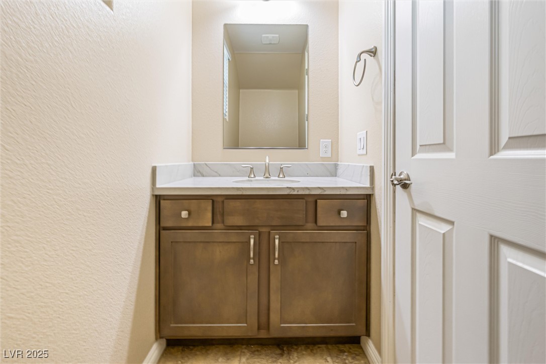 60 Newton Ridge Way Las Vegas, NV 89183 - Photo 36 of 44 Bathroom featuring a textured wall and vanity