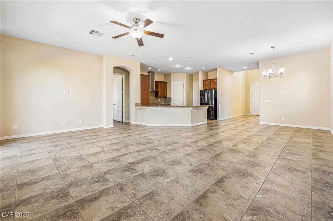 60 Newton Ridge Way Las Vegas, NV 89183 - Photo 4 of 44 Unfurnished living room with recessed lighting, a ceiling fan, arched walkways, and a chandelier