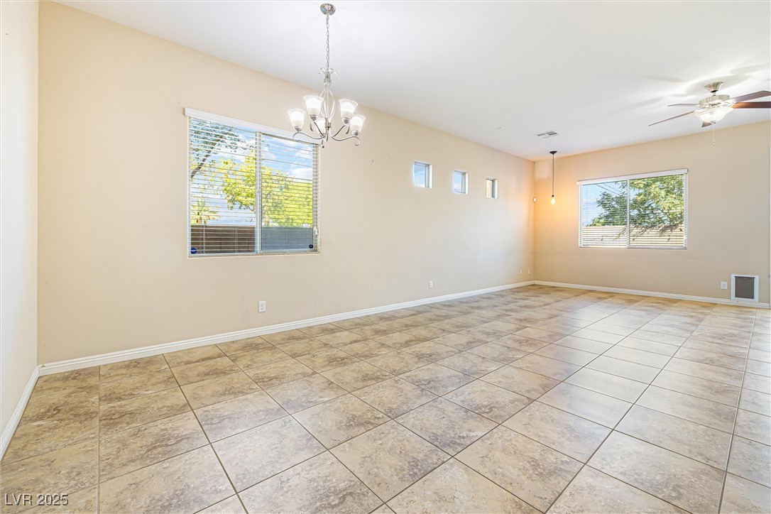 60 Newton Ridge Way Las Vegas, NV 89183 - Photo 5 of 44 Empty room featuring ceiling fan, a chandelier, and light tile patterned floors