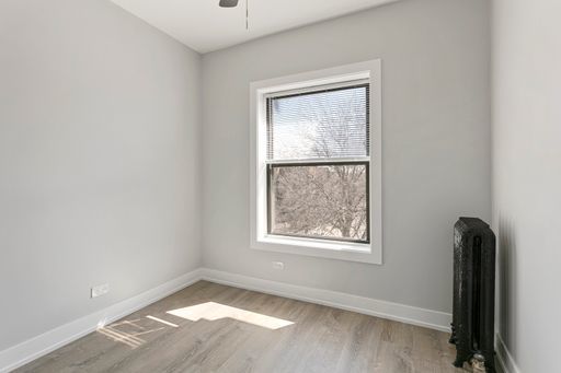 1700 West Juneway Terrace, Unit 3A Chicago, IL 60626 - Photo 11 of 17 a view of an empty room with wooden floor and a window