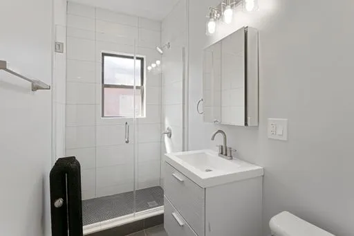 a bathroom with a sink a toilet and shower