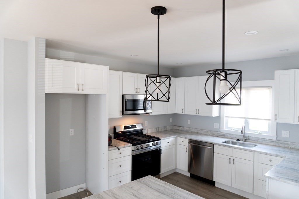 22 Riverside Court Saugus, MA 01906 - Photo 14 of 33 a kitchen with stainless steel appliances granite countertop a sink a stove and a wooden floors
