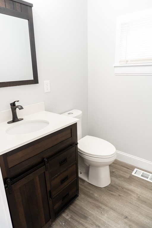 22 Riverside Court Saugus, MA 01906 - Photo 16 of 33 a bathroom with a toilet a sink a vanity and mirror