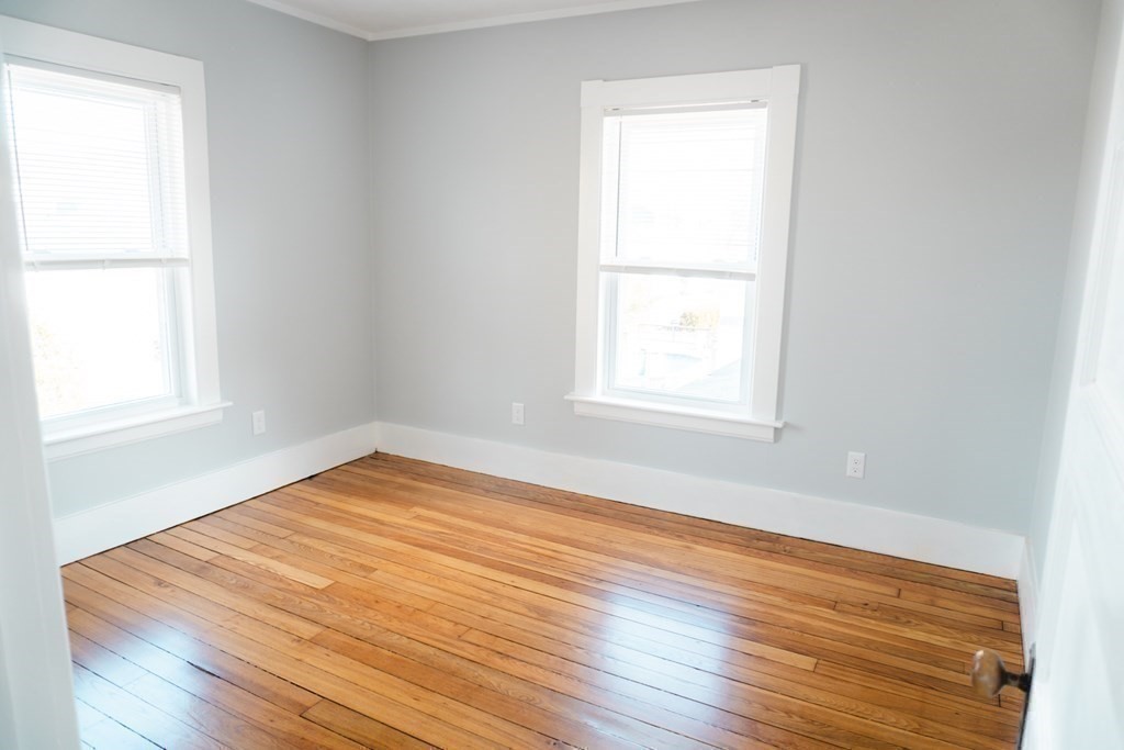 22 Riverside Court Saugus, MA 01906 - Photo 24 of 33 an empty room with wooden floor and windows