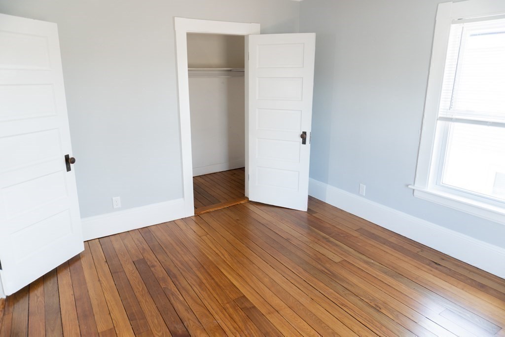 22 Riverside Court Saugus, MA 01906 - Photo 26 of 33 an empty room with wooden floor and windows