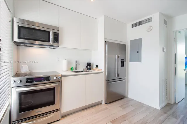 a kitchen with stainless steel appliances and wooden floor