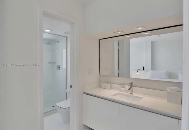 a bathroom with a granite countertop sink toilet and shower