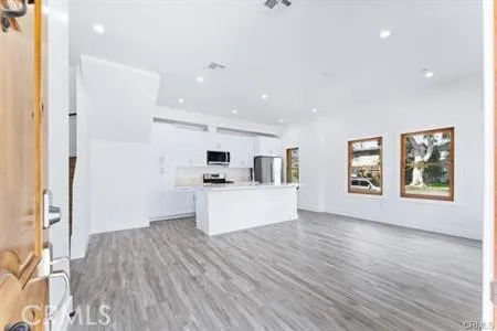 a view of kitchen with wooden floor and electronic appliances