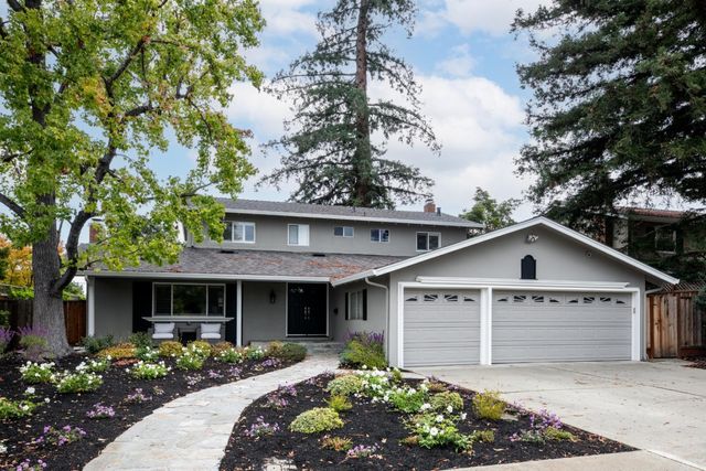 a front view of house with a garden