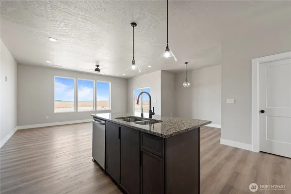 a kitchen with a sink a counter space and wooden floor