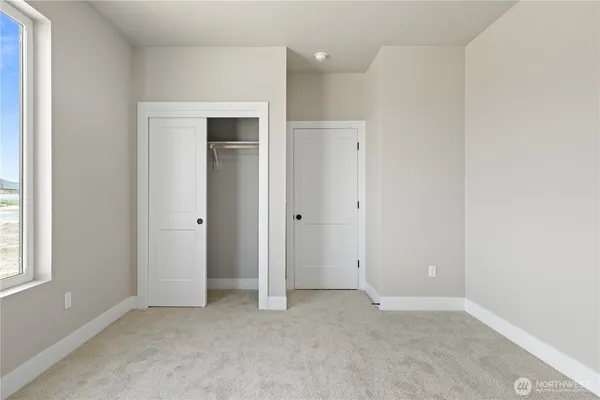 an empty room with windows and closet