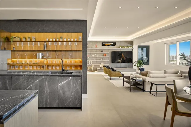 a living room with couches a flat screen tv and kitchen view