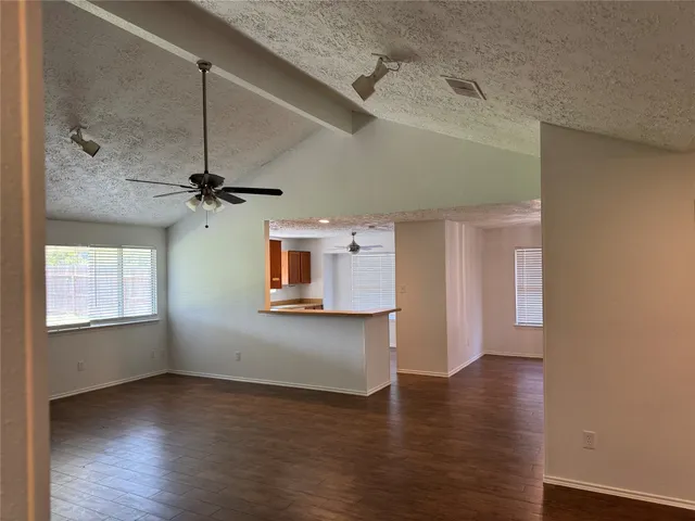 a view of a livingroom with wooden floor and a ceiling fan