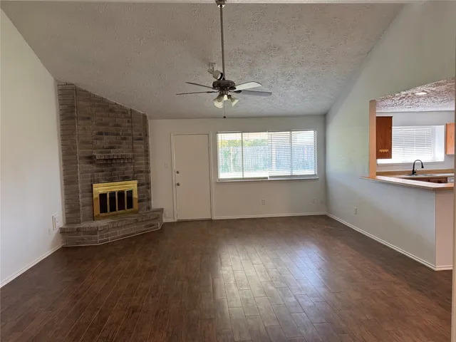 a view of an empty room with a fireplace and a window