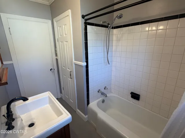 a bathroom with a tub a sink and a shower
