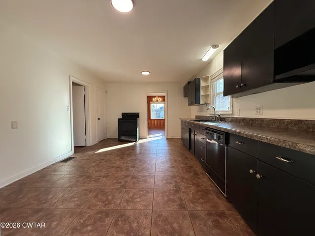 a large kitchen with stainless steel appliances granite countertop a stove and a sink
