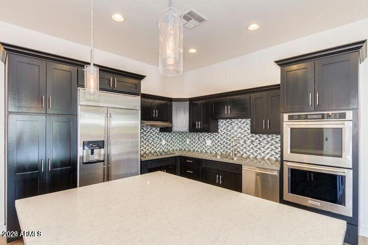 3814 North 9th Street Phoenix, AZ 85014 - Photo 6 of 18 a kitchen with stainless steel appliances kitchen island granite countertop a refrigerator a stove and a sink with wooden floor