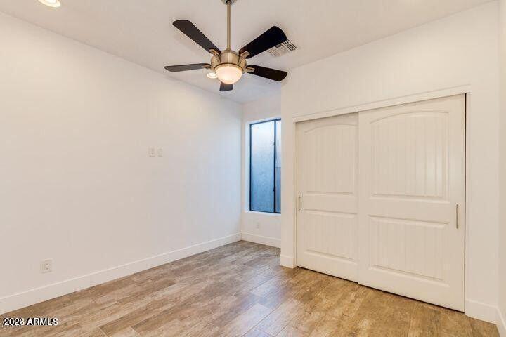 3814 North 9th Street Phoenix, AZ 85014 - Photo 9 of 18 an empty room with wooden floor and a ceiling fan