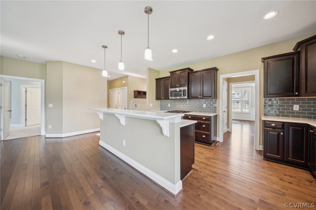 7004 Benhall Circle Glen Allen, VA 23059 - Photo 19 of 50 a large kitchen with stainless steel appliances granite countertop a stove a sink dishwasher a refrigerator white cabinets and wooden floor
