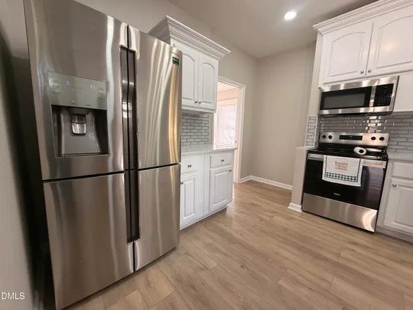 a kitchen with stainless steel appliances a refrigerator microwave and sink
