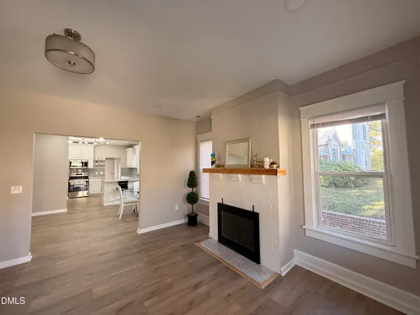 a view of a livingroom with wooden floor and a fireplace