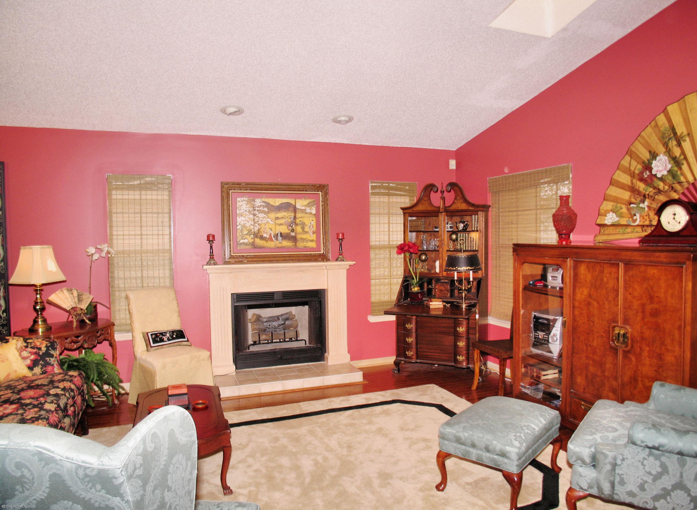 5434 Spring Brook Road Jacksonville, FL 32277 - Photo 2 of 4 a living room with furniture a fireplace and a flat screen tv