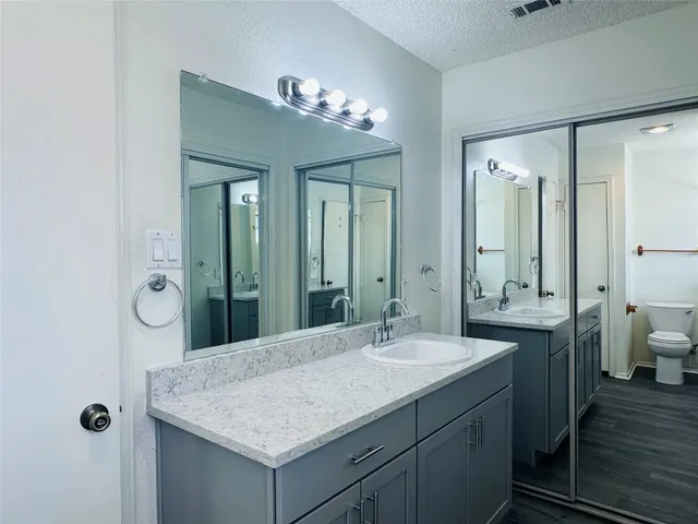 a bathroom with a granite countertop sink a large mirror and a shower