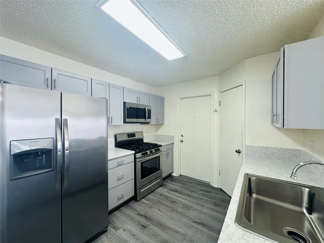 a kitchen with a refrigerator sink and stove