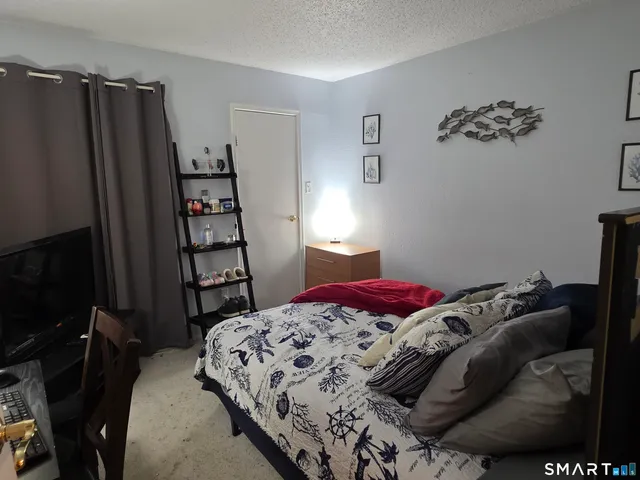 a bedroom with a large bed and a lamp