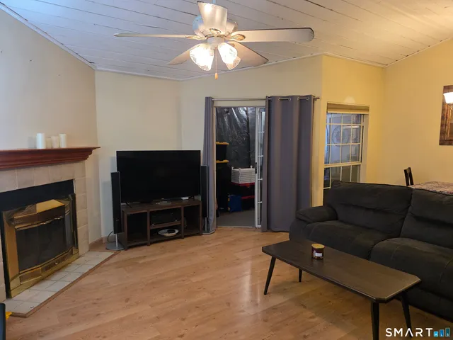 a living room with furniture a flat screen tv and a fireplace