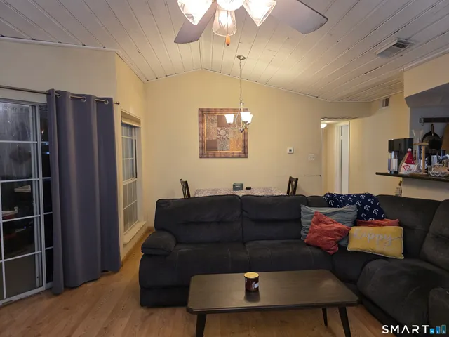 a living room with furniture a ceiling fan and a window