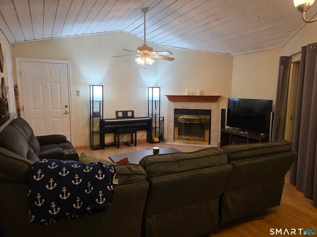 a living room with furniture a flat screen tv and a fireplace