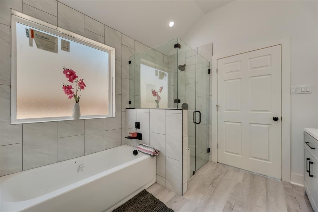 6031 Plum Dale Road Dallas, TX 75241 - Photo 16 of 23 a bathroom with a tub a sink and a shower