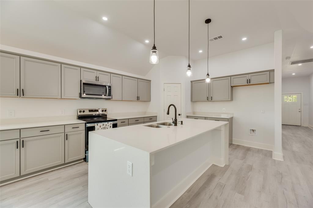 6031 Plum Dale Road Dallas, TX 75241 - Photo 6 of 23 a kitchen with stainless steel appliances a sink a stove a refrigerator cabinets and chairs