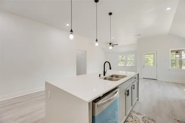 a kitchen with stainless steel appliances granite countertop a sink a faucet and a window