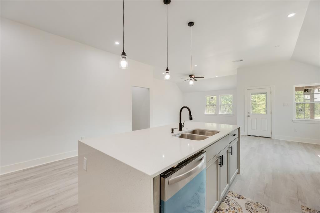 6031 Plum Dale Road Dallas, TX 75241 - Photo 7 of 23 a kitchen with stainless steel appliances granite countertop a sink a faucet and a window
