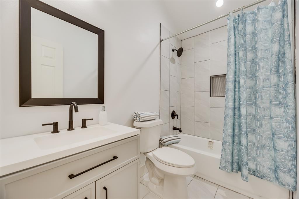 6031 Plum Dale Road Dallas, TX 75241 - Photo 10 of 23 a bathroom with a sink a toilet and shower