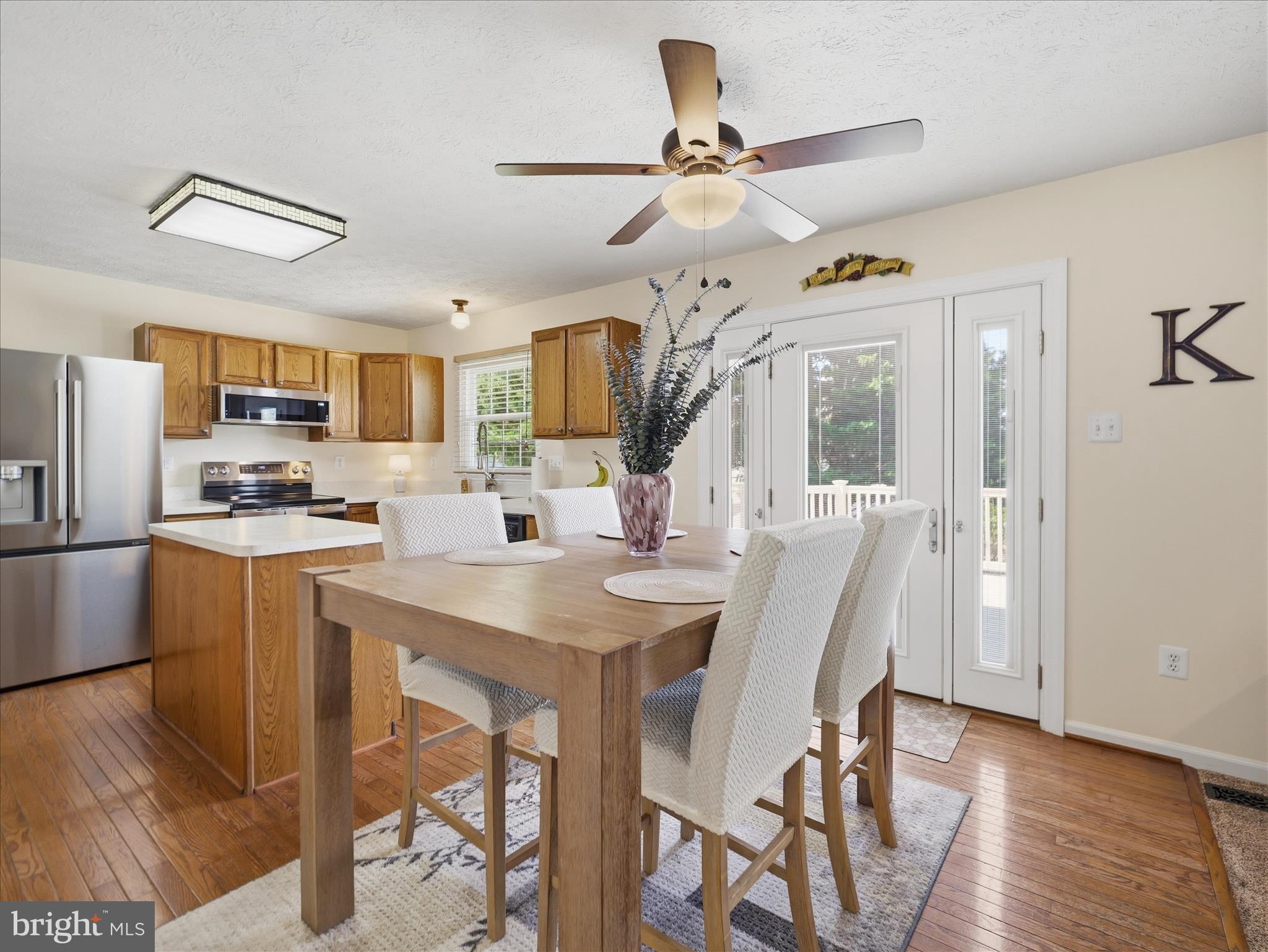 7 Coldstream Court Boonsboro, MD 21713 - Photo 11 of 43 a kitchen with stainless steel appliances kitchen island granite countertop a refrigerator a stove a microwave oven a sink with island chairs and wooden floor