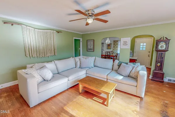 a living room with furniture and a wooden floor