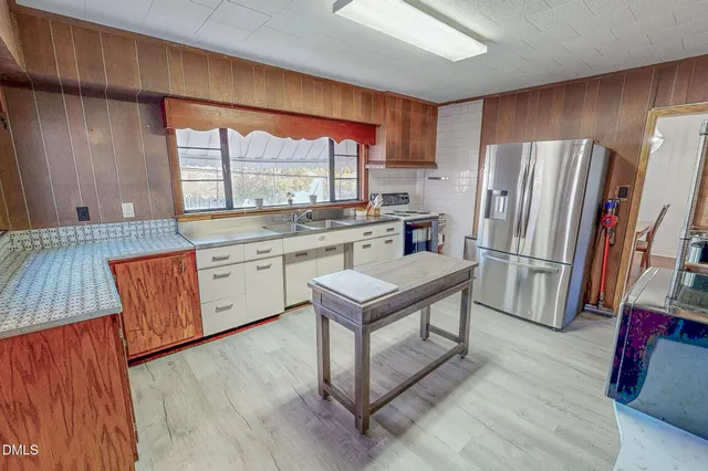 a kitchen with a sink a counter space and a refrigerator