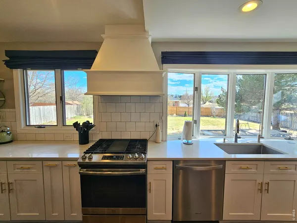 a large kitchen with lots of counter space sink and chairs
