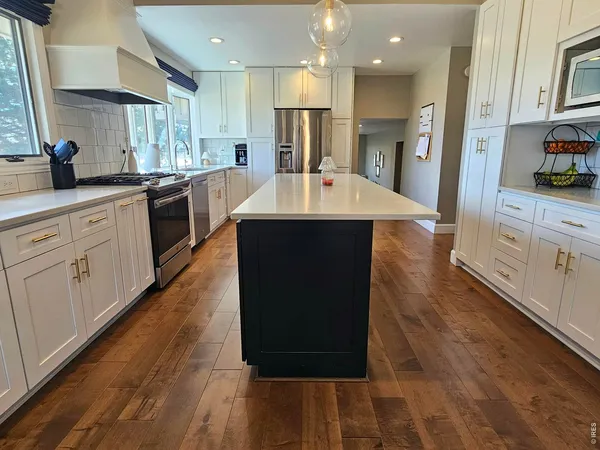 a large kitchen with kitchen island a large counter space and stainless steel appliances