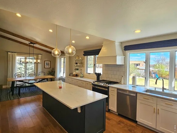 a kitchen with stainless steel appliances a sink cabinets and wooden floor