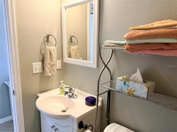 a bathroom with a sink and mirror with toilet