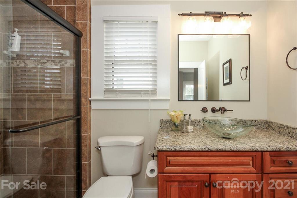 1637 Club Road Charlotte, NC 28205 - Photo 22 of 28 a bathroom with a granite countertop toilet sink and mirror