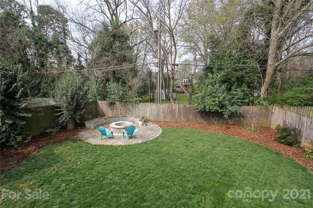1637 Club Road Charlotte, NC 28205 - Photo 25 of 28 a backyard of a house with table and chairs potted plants and large tree