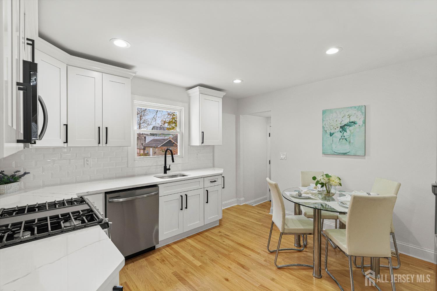 709 Front Street Dunellen, NJ 08812 - Photo 13 of 34 a kitchen with a sink chairs and cabinets